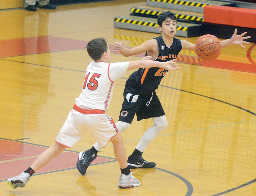 Chase Crosby (center) looks to deflect a pass from St. James&rsquo; Westin Ridenhour during Owensville&rsquo;s 30-14 victory in seventh-grade basketball action last Wednesday afternoon at St. James Middle School.