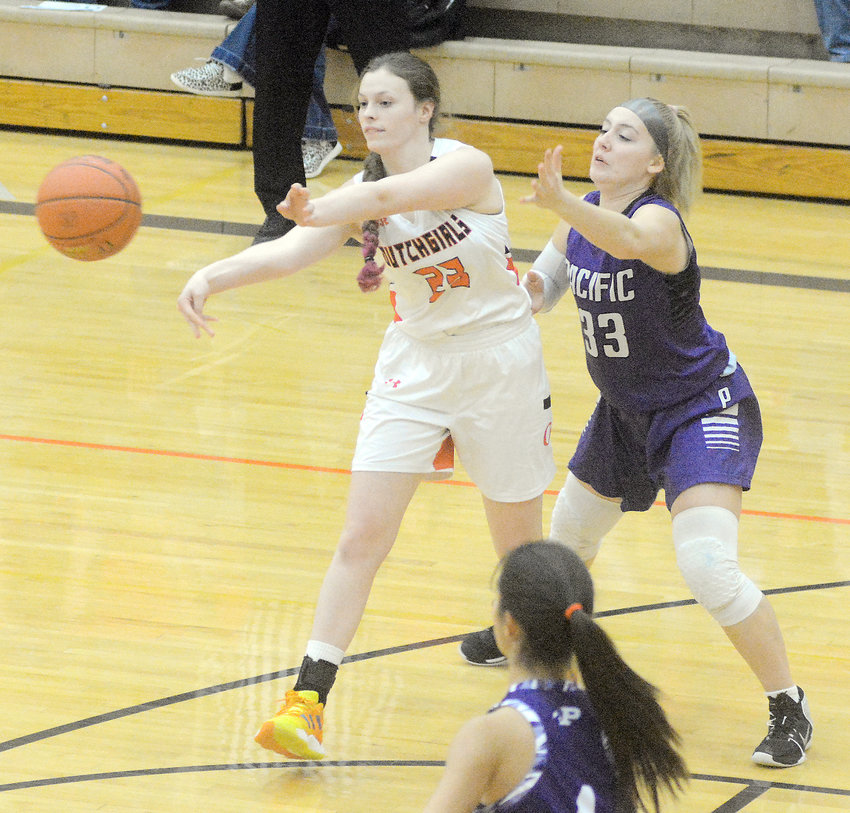 KIana Guerrero (left) passes the ball away from a Pacific defender during senior-night basketball Monday at Owensville High School. OHS will host Columbia Hickman Friday night at 5:30 p.m.