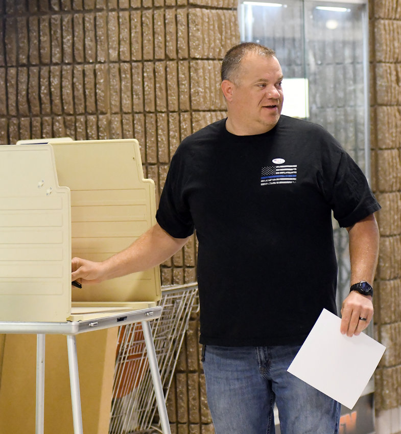 SHERIFF SCOTT EILER visits briefly Tuesday with election judges after marking his ballot at the Rural Canaan precinct at Owensville High School. Eiler was only the 28th voter to cast a ballot by 8 a.m. April 5.