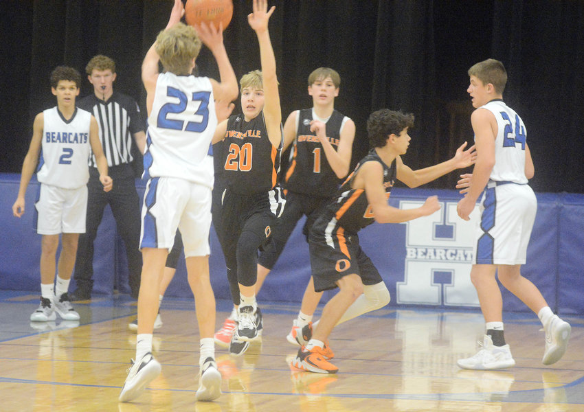 Ryker Ash (center) takes a shot for Hermann while Owensville&rsquo;s Wyatt Lewis (20) gets a hand up looking to contest the shot during Monday night basketball action at Hermann Middle School.
