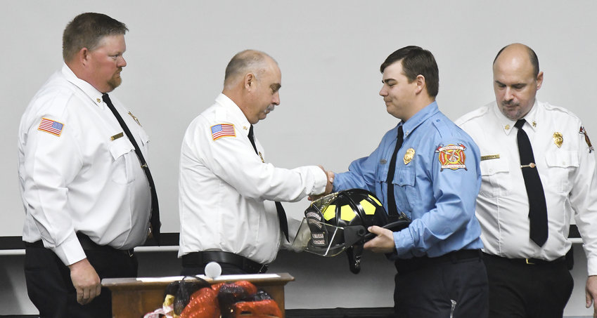 Owensville Fire Department Lt. Dylan Nochta (left) receives a helmet Saturday as the 2022 Firefighter of the Year from Deputy Chief Jeff Limberg as Assistant Chief Martin Schlottach (far left) and Chief Jeff Arnold look on.