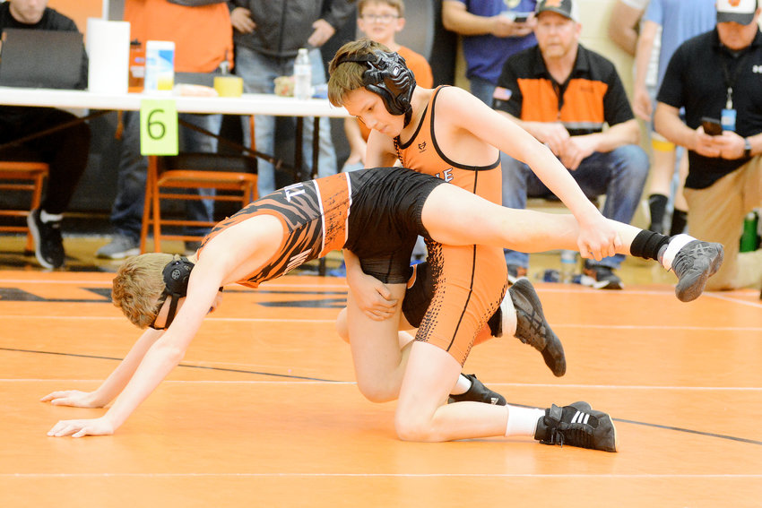 Mason Turner (solid orange singlet) gains control of Macon&rsquo;s Ben Seiler during their second-round consolation match at 100 pounds in the 12-and-under division during Saturday&rsquo;s Missouri USA District 7 Wrestling Tournament hosted by Owensville High School. Turner won a 6-2 decision over his orange and black opponent.