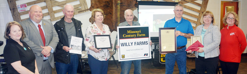 University of Missouri Extension Administrative Assistant Christy Metzger (left), State Rep. Bennie Cook, Willy family members John Badger, Karen Badger, Victor Willy, John Chapman, Donna Chapman and MU Extension Council member Sarah Stratman pose with the Willy Farms sign at the April 3 Century Farm dinner.