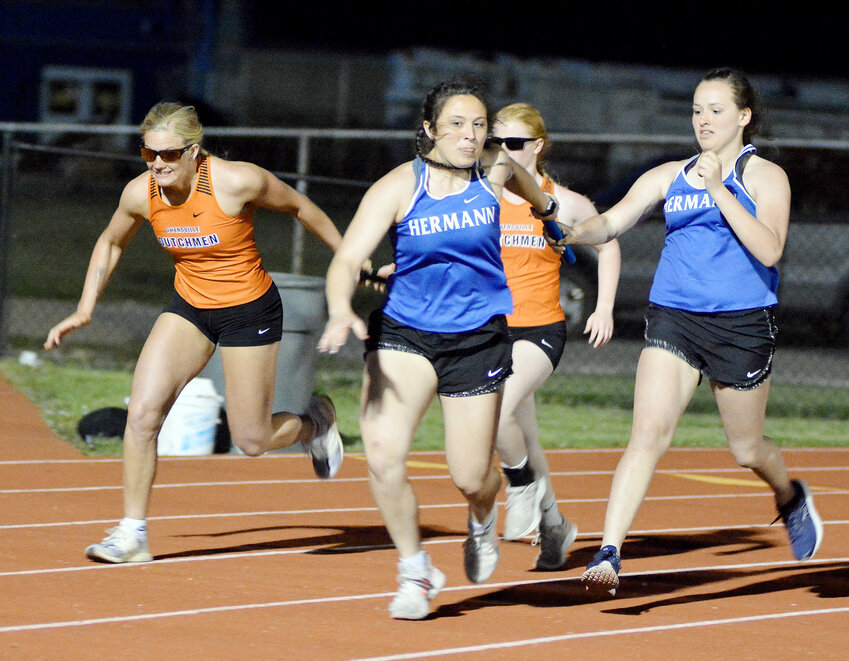 Josie Gerlemann (top, far left) grabs the baton from Dutchgirl teammate Liz Adams while Hermann&rsquo;s Tirzah Dodorico (center) grabs the baton from Faith Gabathuler for Hermann in the girls 4x100-meter throwers relay during Friday&rsquo;s OHS Relays.