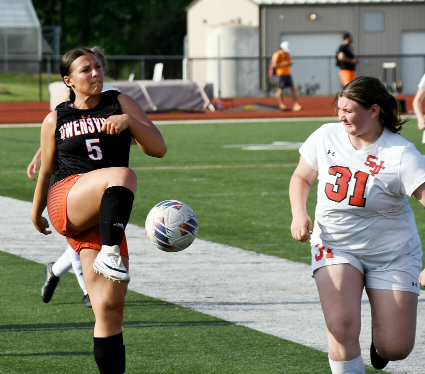 Drew Copeland (left) sends the ball up field during Owensville Dutchgirl soccer senior night action Monday at Dutchmen Field while St. James&rsquo; Baylee Jones defends for the visiting Lady Tigers. Copeland was one of eight seniors recognized for their contributions to the Dutchgirl soccer program prior to their 4-0 victory over St. James.