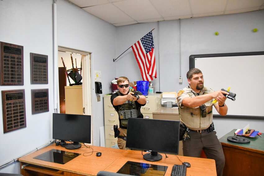 Ryan Fowler (left) and Tanner Hinson clear the Belle High School office July 13 during active shooter training.