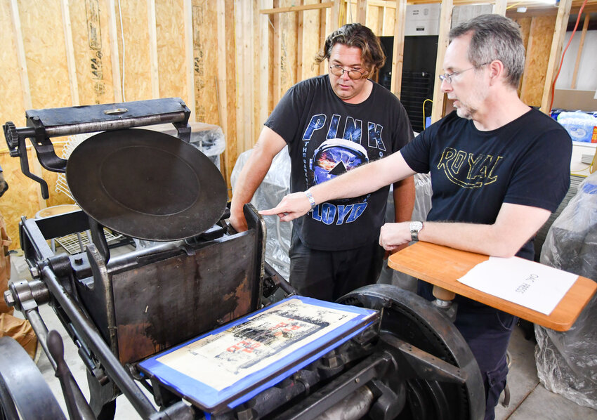 Jonathan S. Baker (left) and Tony S. Brewer examine OAC 19th-century printing press. Along with Snow Mathews, they spent a week in Belle using the press to print their chapbook &ldquo;Ekphrasis.&rdquo;