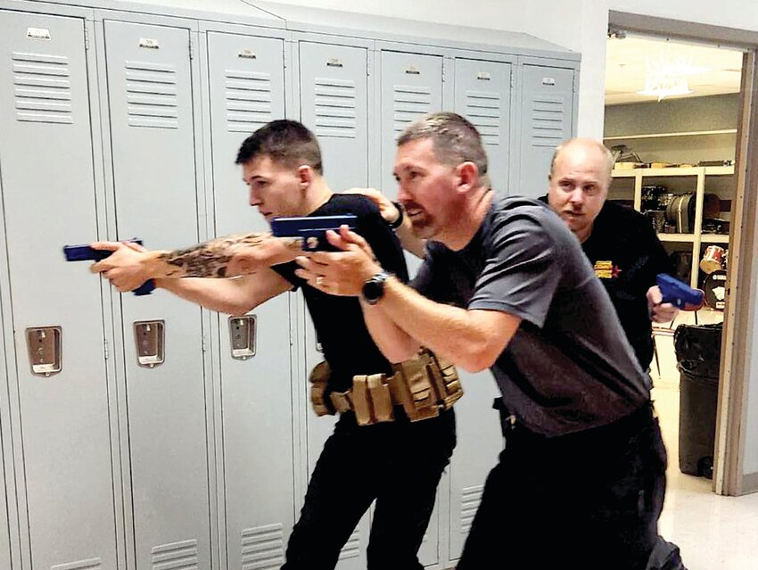 Osage County deputies Chris Morgan and Ben Sallin make a hallway sweep during last week&rsquo;s active-shooter training at Linn R-2. They were joined by a deputy from another agency.