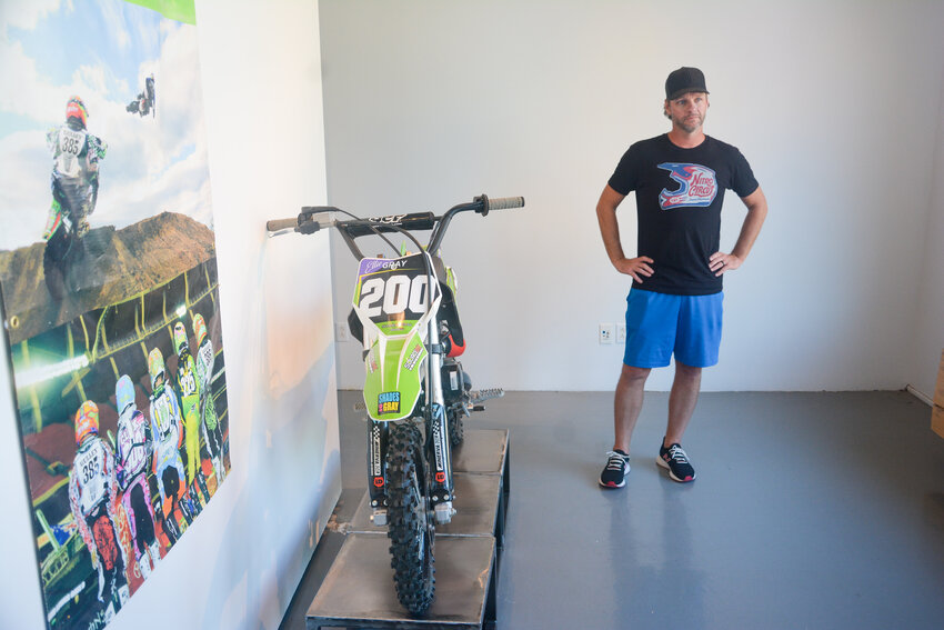 Josh Gray stands next to a motocross bike he designed for his daughter Ellie. The work of Gray, a Belle local, will remain on display through Sept. 2 in the Osage Arts Community Art Center.