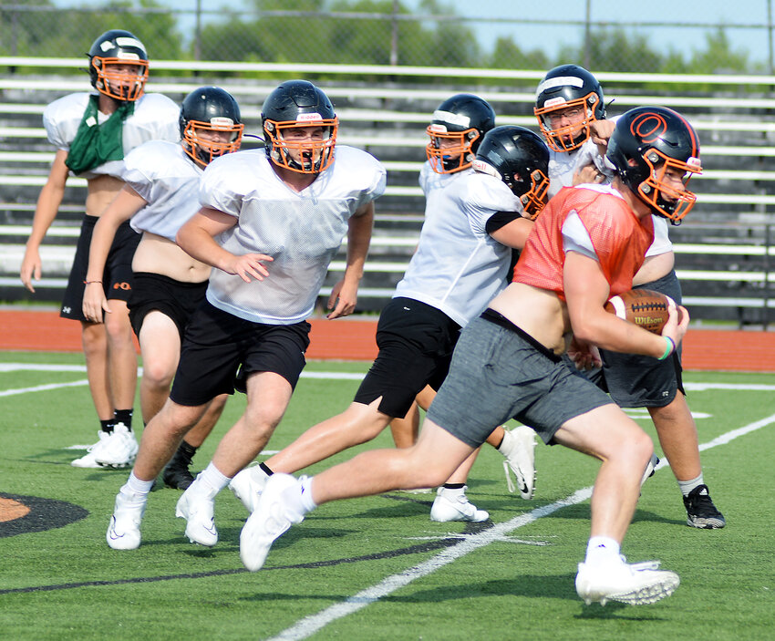 Blake Elliott (far right) locates a hole in the defense during a recent practice session last week for Owensville Dutchmen football at Dutchmen Field. Now a senior, Elliott will lead the Dutchmen beginning this Friday by hosting their first-ever preseason jamboree beginning at 6 p.m. Teams competing along with the host orange and black include Linn&rsquo;s Wildcats, Fulton&rsquo;s Hornets, Hermann&rsquo;s Bearcats, Montgomery County&rsquo;s Wildcats and Russellville&rsquo;s Indians. First-year Dutchmen head football coach Dustin Howard will make his head-coaching debut on Friday, Aug. 25 in a Highway 19 showdown on the road  at Cuba High School against the host Wildcats with a 7 p.m., kickoff. Dutchmen fans will have to wait until Friday, Sept. 8 to see the orange and black at Dutchmen Field in their home opener against Warrenton&rsquo;s Warriors.