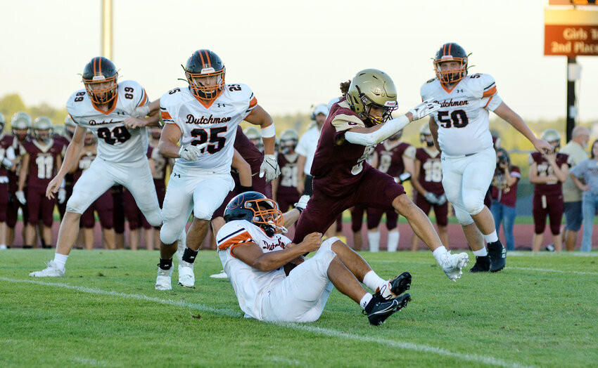 Isaiah Gates (center) grabs a hold of Eldon&rsquo;s Andrew Beanland while fellow Dutchmen defenders (from left) Dalton Pyrtle, Logan Bailey and Landen Diestelkamp look to help Gates bring down the Mustang ball carrier during Owensville&rsquo;s 35-31 victory Friday night at Victor Field inside Mustang Memorial Park.