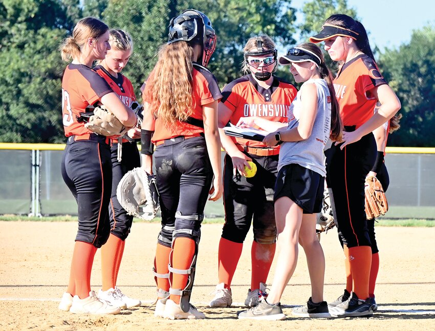 Owensville Dutchgirl head softball coach Hannah Koppelmann (white shirt) has a conference with her infielders during OHS&rsquo; 13-2 loss Thursday in Osage County at Linn.