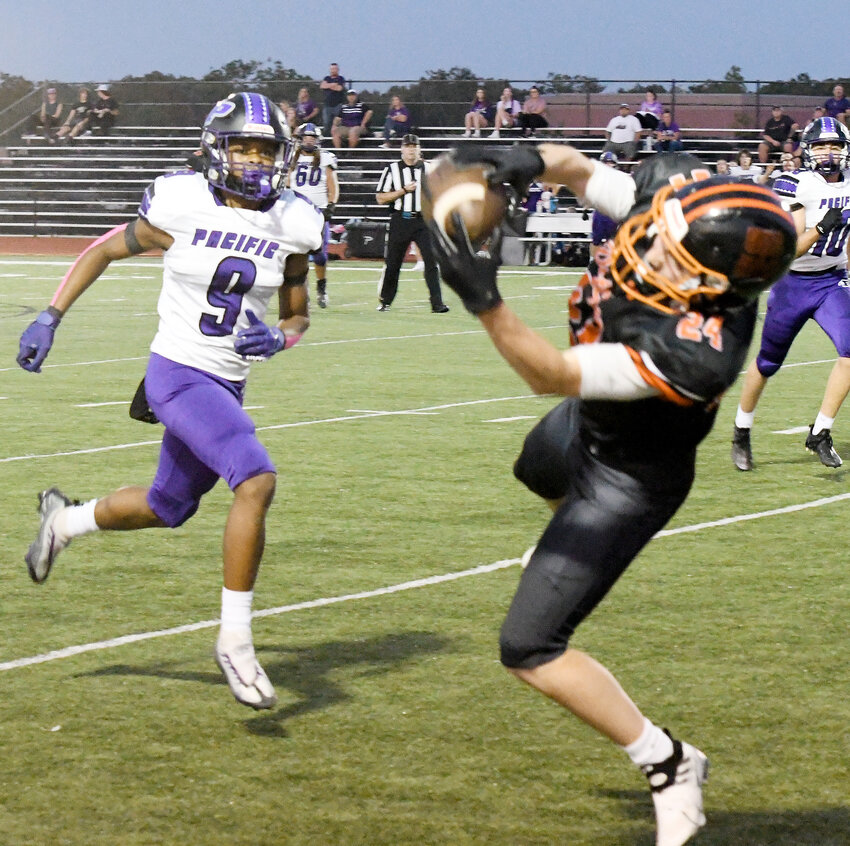Tanner Meyer (right) hauls in one of his five catches Friday night during Owensville&rsquo;s 41-24 loss to Pacific&rsquo;s Indians coached by former Dutchmen sideline boss Paul Day.