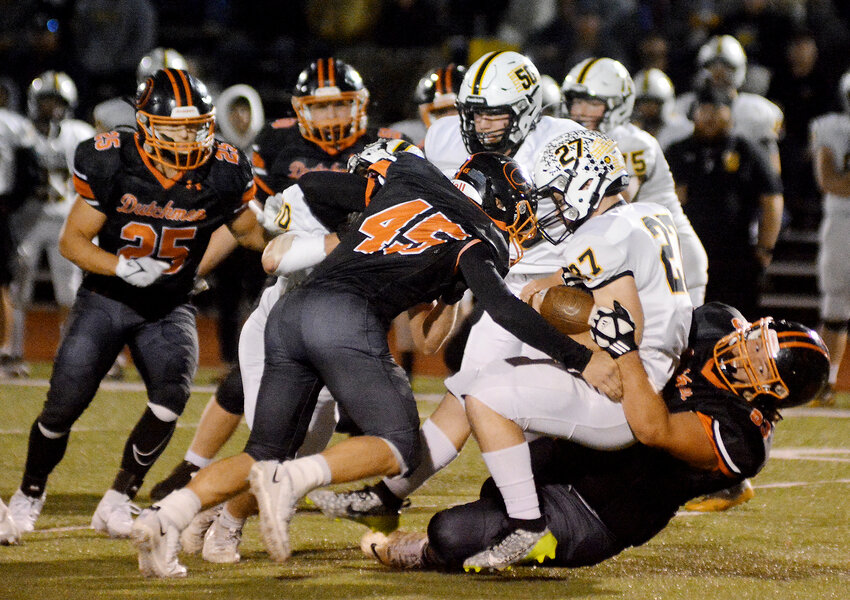 Hayden Shoemaker (far right) drags Sullivan running back Franky Erxleben down to the Dutchmen Field turf Friday night with help from Jaden Gerlemann (45) during Owensville&rsquo;s 28-7 homecoming loss to the visiting Eagles.