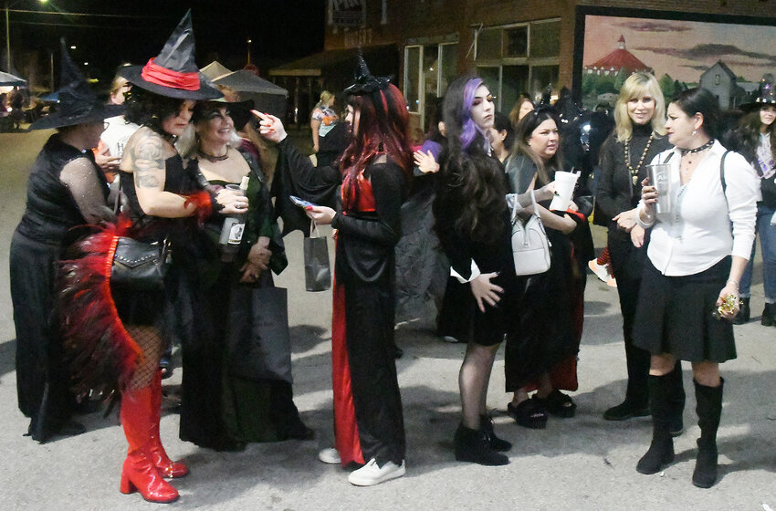 WITCHes Night Out participants visit along Owensville&rsquo;s First Street on Oct. 26 while waiting for the start of the costume contest. Over $1,000 was raised for two local community service projects.