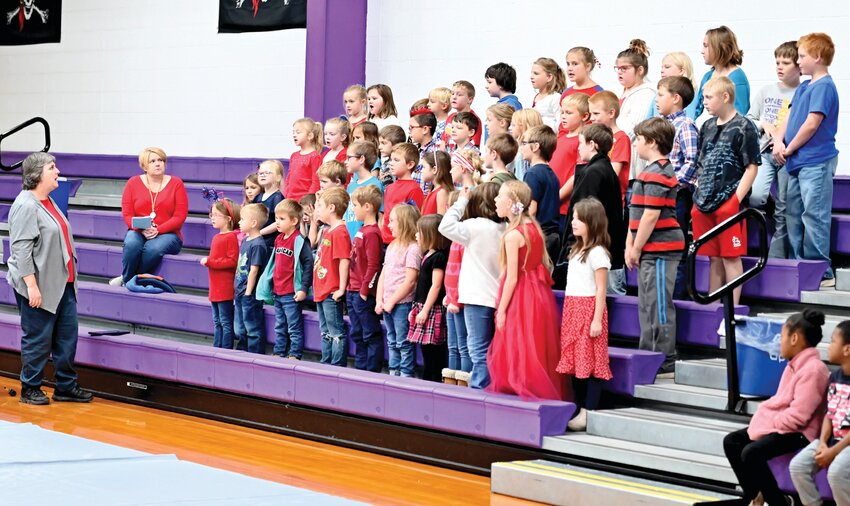 Chamois Band Teacher Beth Sieg leads elementary students in a song at Friday&rsquo;s Veterans Day Assembly.
