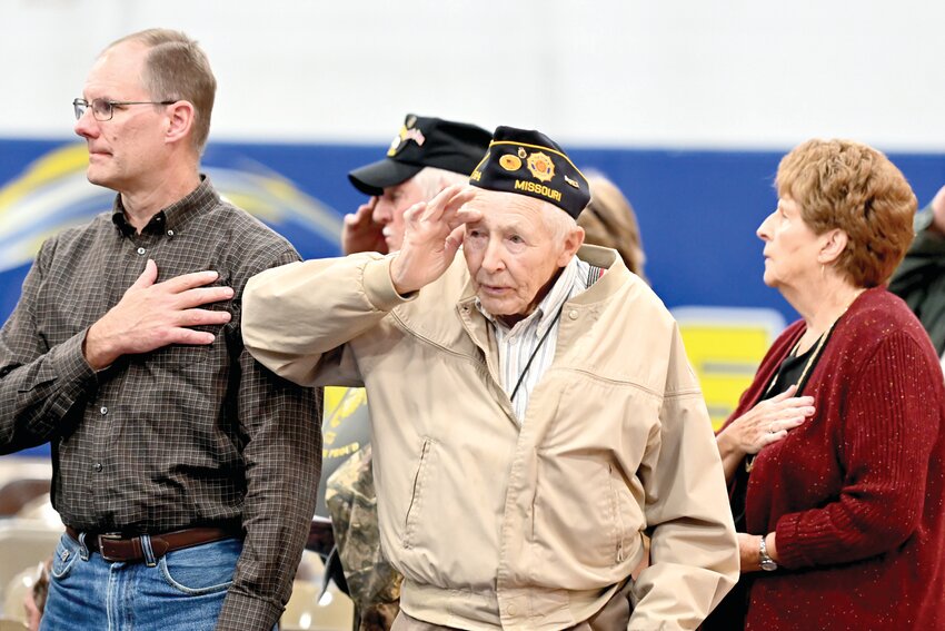 At a ceremony at Fatima, veterans and family members salute or cover their hearts during the Pledge of Allegiance.