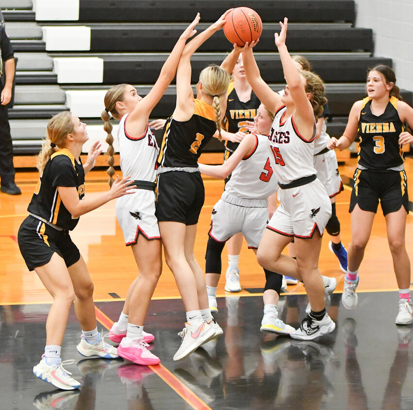 Lainey Magner (center) battles for a rebound for Vienna&rsquo;s Eagles against Eugene&rsquo;s Lady Eagles during the seventh-place game at Eugene&rsquo;s Tournament Friday afternoon.