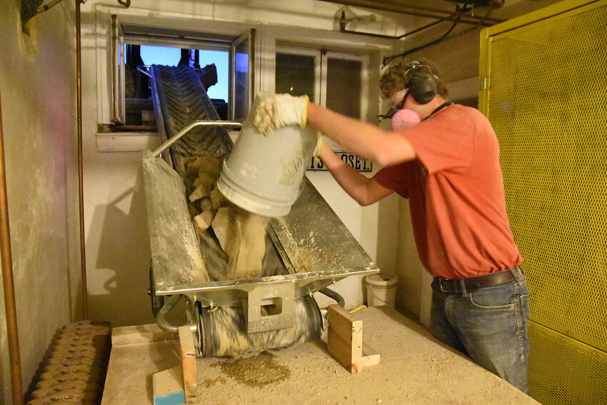 Clayton Mellendorf with Franklin County Construction dumps 5-gallon buckets of excavated rock Thursday evening from Gasconade County courthouse basement onto a conveyor belt to remove the material through a window on the west side of the building. Work on the elevator pit was being performed after hours due to noise and dust issues.