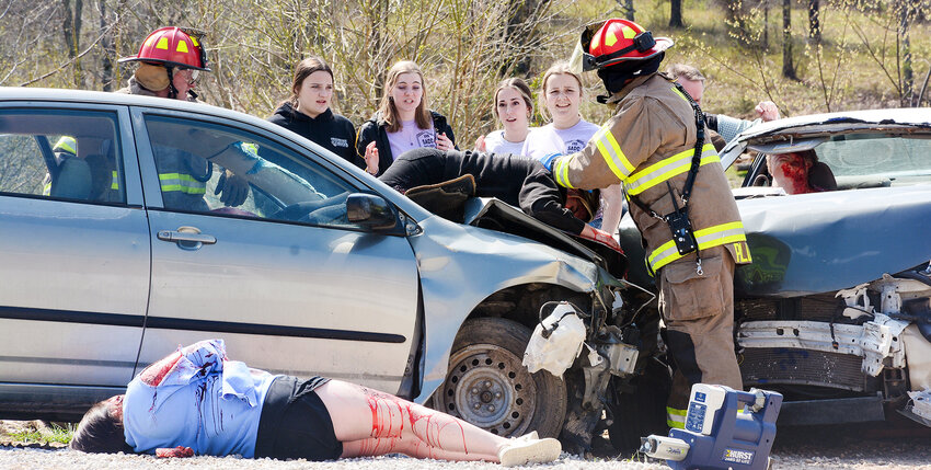 Vienna Fire Protection District firefighters examine the damage and injuries in a staged car crash at Vienna High School on March 21. The docudrama warning students about the dangers of driving impaired was presented by the school&rsquo;s Students Against Drunk Driving organization and the Meramec Regional Planning Commission.