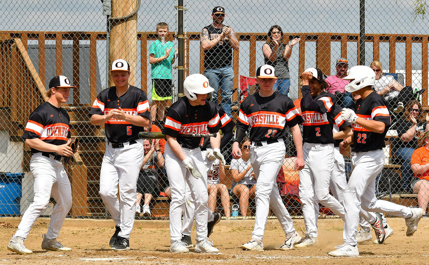 Chris Allen (far right) is awaited by his Owensville Dutchmen baseball teammates Saturday afternoon after hitting one of his two home runs against Linn’s Wildcats in road baseball at Vienna City Park.