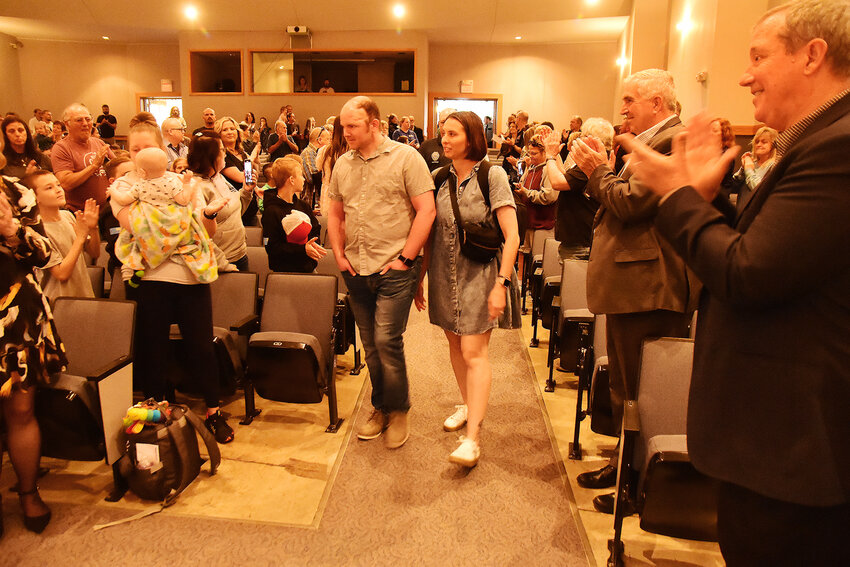 ADAM SULLENTRUP and his wife, Michelle, walk into the Hermann High School Auditorium to a standing ovation Saturday morning. Sullentrup has undergone extensive rehabilitation since being shot in the head in March 2023. He underwent surgery in February to replace the piece of his skull which was removed during initial life-saving procedures. Sullentrup’s family thanked emergency responders to his shooting incident with quilts they created.