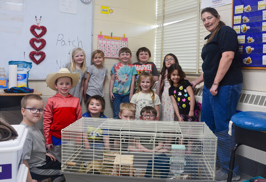 Lisa Swindell’s 2023-24 kindergarten class poses for a photo with class pets Patch and Nibbles during a pajama day earlier in the school year. The class welcomed the guinea pigs after Swindell obtained them through a class pet grant.