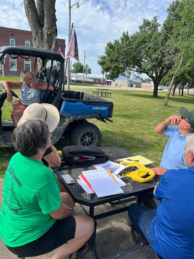 Ron Bentch, (far right) Rock Island Trail Development Coordinator with Missouri State Parks, explains to a group of volunteers that a bat study must be conducted before certain dying trees in Roadside Park can be taken down. Bentch’s department has given preliminary approval to build a two-story bandstand, a footbridge and an arbor in the small park.